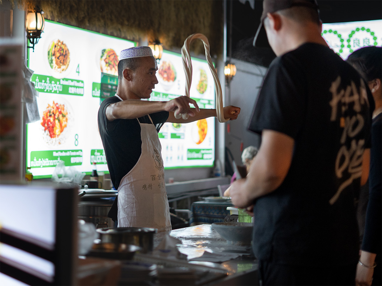Cocinero preparando noodles en un mercado de Luang Prabang, Laos
