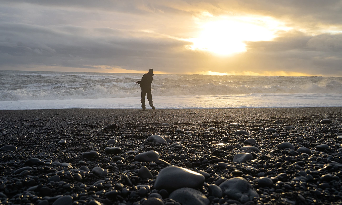 Caminando solo por una playa de arena negra en Islandia